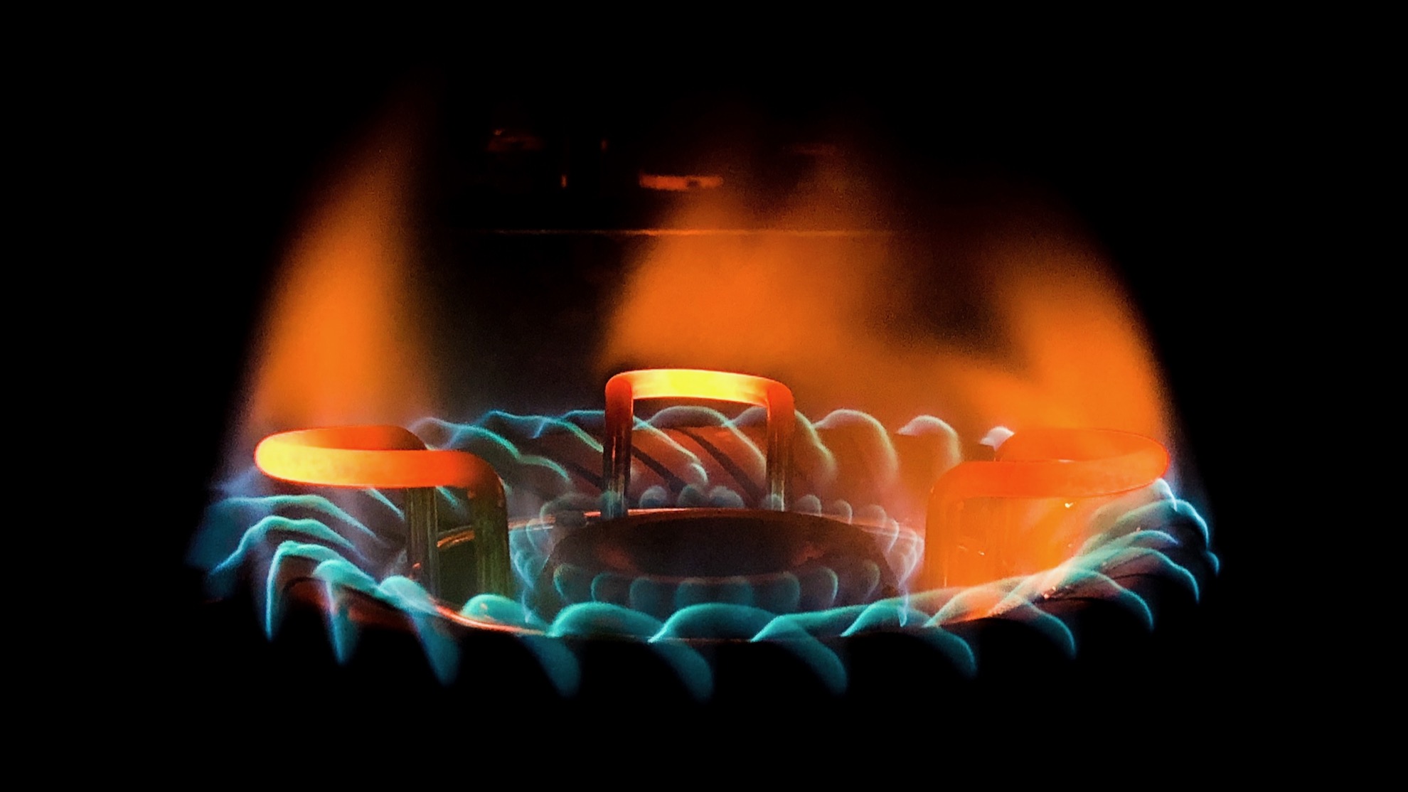 closeup shot of a beautiful blue green flame in a gas stove